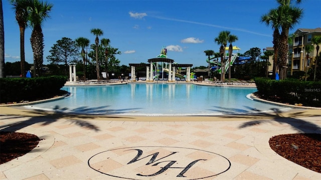 7682 Sir Kaufmann Ct, Kissimmee, FL 34747 - community pool with a water play area, a water slide, and a patio