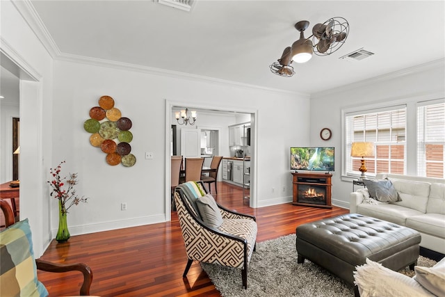 2312 S Summerlin Ave, Orlando, FL 32806 - living area featuring a chandelier, crown molding, dark wood-type flooring, and a warm lit fireplace