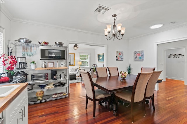 2312 S Summerlin Ave, Orlando, FL 32806 - dining area featuring a chandelier, crown molding, and hardwood / wood-style flooring
