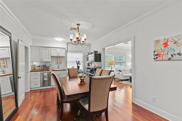 2312 S Summerlin Ave, Orlando, FL 32806 - dining room with ornamental molding, a chandelier, and hardwood / wood-style flooring