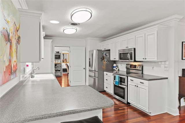 2312 S Summerlin Ave, Orlando, FL 32806 - kitchen featuring stainless steel appliances, ornamental molding, white cabinetry, and dark wood-style floors