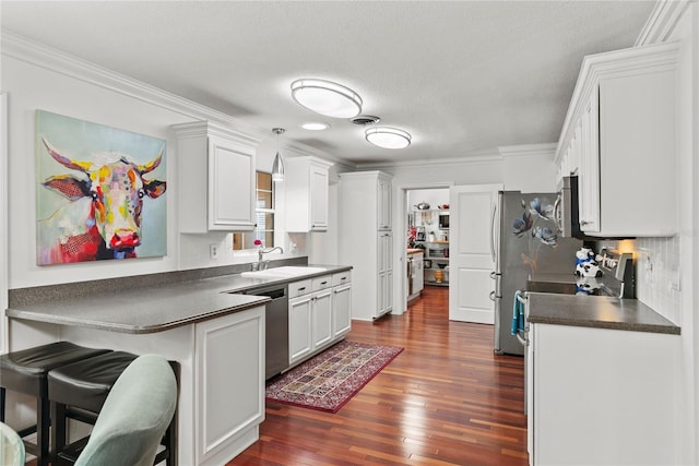 2312 S Summerlin Ave, Orlando, FL 32806 - kitchen with appliances with stainless steel finishes, dark countertops, crown molding, dark wood-type flooring, and backsplash
