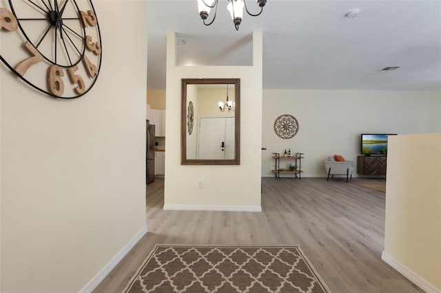 1065 Universal Rest Pl, Kissimmee, FL 34744 - corridor with a chandelier and light wood-type flooring