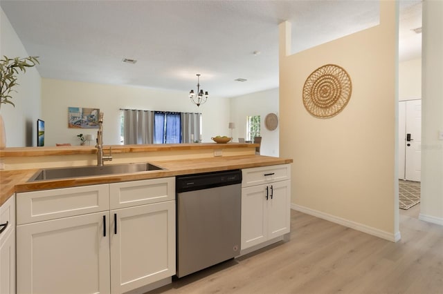 1065 Universal Rest Pl, Kissimmee, FL 34744 - kitchen with dishwasher, wood counters, light wood-style flooring, a chandelier, and white cabinetry