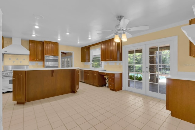 202 Riverview Dr, Longwood, FL 32779 - kitchen featuring wall chimney exhaust hood, appliances with stainless steel finishes, decorative backsplash, french doors, and light countertops