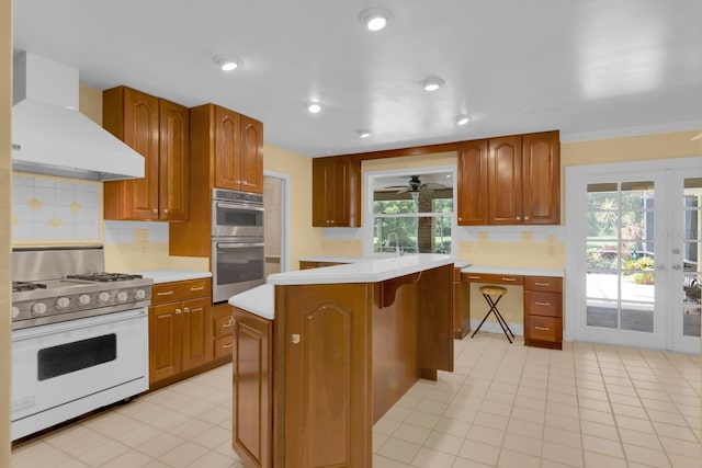 202 Riverview Dr, Longwood, FL 32779 - kitchen featuring gas range gas stove, wall chimney exhaust hood, double oven, light countertops, and backsplash