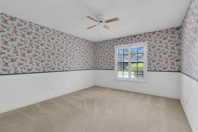 202 Riverview Dr, Longwood, FL 32779 - carpeted spare room featuring wallpapered walls, a ceiling fan, wainscoting, and a textured ceiling
