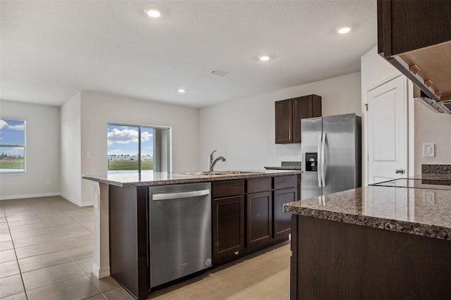 17127 Harvest Moon Way, Bradenton, FL 34211 - kitchen featuring stainless steel appliances, dark brown cabinetry, stone countertops, a center island with sink, and light tile patterned floors
