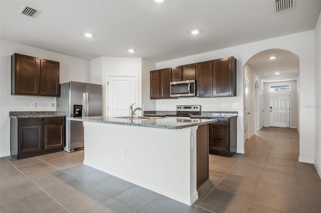 17127 Harvest Moon Way, Bradenton, FL 34211 - kitchen with stainless steel appliances, arched walkways, light tile patterned floors, and recessed lighting