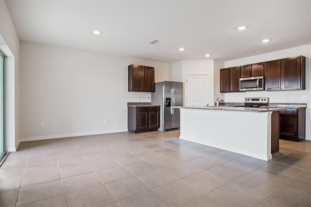 17127 Harvest Moon Way, Bradenton, FL 34211 - kitchen featuring appliances with stainless steel finishes, recessed lighting, dark brown cabinetry, light tile patterned flooring, and a center island with sink