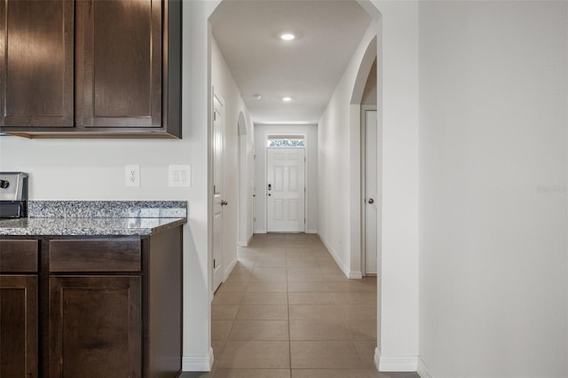 17127 Harvest Moon Way, Bradenton, FL 34211 - hallway featuring light tile patterned flooring, arched walkways, and recessed lighting