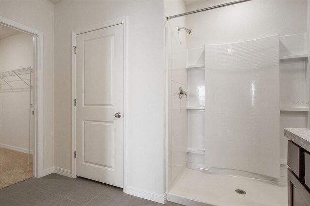 17127 Harvest Moon Way, Bradenton, FL 34211 - bathroom with a shower stall, a walk in closet, tile patterned floors, and vanity