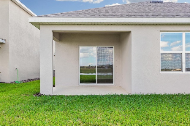 17127 Harvest Moon Way, Bradenton, FL 34211 - view of side of property with a shingled roof, a yard, stucco siding, and a patio area