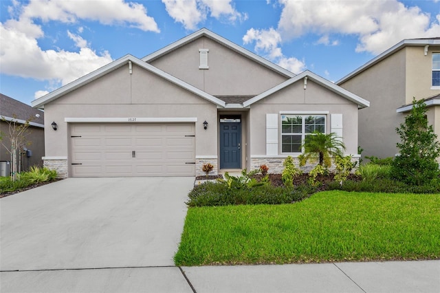 17127 Harvest Moon Way, Bradenton, FL 34211 - view of front of home featuring stone siding, stucco siding, concrete driveway, and a garage