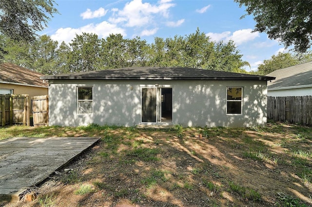 979 Mayfair St, Eustis, FL 32726 - back of property with a fenced backyard, stucco siding, and a wooden deck
