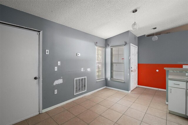 979 Mayfair St, Eustis, FL 32726 - empty room with light tile patterned floors, a textured ceiling, and vaulted ceiling