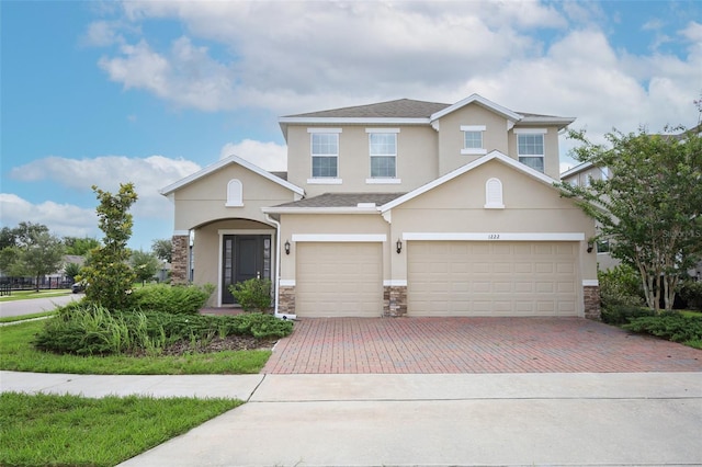 1222 Castlevecchio Loop, Orlando, FL 32825 - view of front of property featuring stucco siding, decorative driveway, and stone siding
