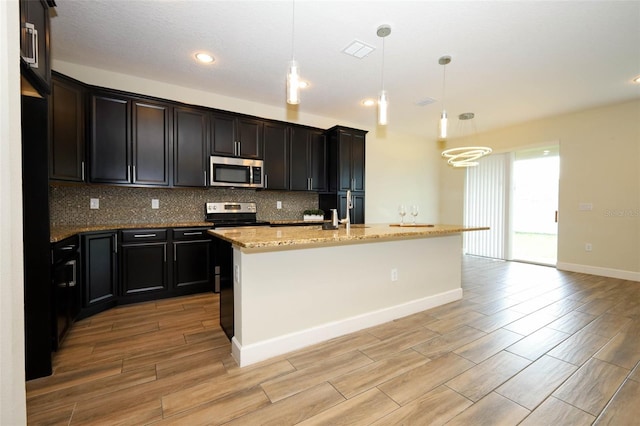 1222 Castlevecchio Loop, Orlando, FL 32825 - kitchen with stainless steel microwave, light wood-style floors, backsplash, light stone counters, and recessed lighting
