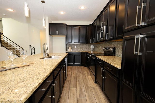 1222 Castlevecchio Loop, Orlando, FL 32825 - kitchen featuring appliances with stainless steel finishes, light stone countertops, light wood finished floors, hanging light fixtures, and recessed lighting