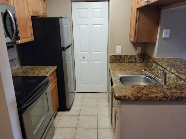 236 Afton Sq Unit 207, Altamonte Springs, FL 32714 - kitchen featuring electric range, stainless steel microwave, light tile patterned floors, and dark stone counters
