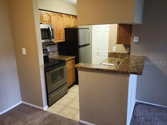 236 Afton Sq Unit 207, Altamonte Springs, FL 32714 - kitchen featuring appliances with stainless steel finishes, a peninsula, and dark stone countertops