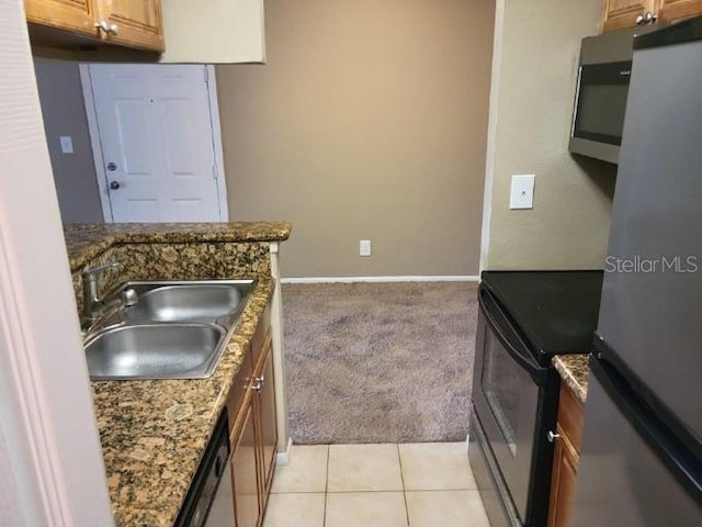 236 Afton Sq Unit 207, Altamonte Springs, FL 32714 - kitchen featuring appliances with stainless steel finishes, light colored carpet, and brown cabinetry