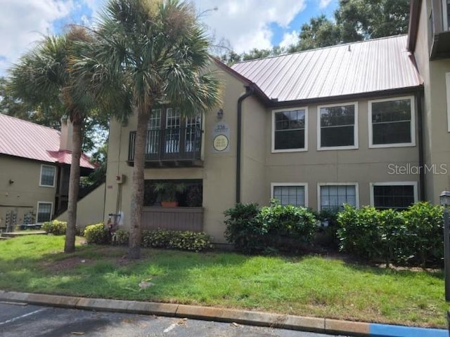 236 Afton Sq Unit 207, Altamonte Springs, FL 32714 - view of home's exterior with a yard, stucco siding, and a metal roof