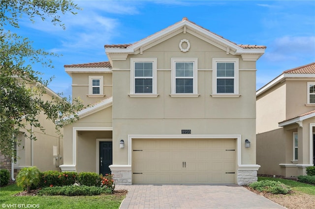8955 Fluffy Lie Ct, Davenport, FL 33896 - view of front facade with a tiled roof, stucco siding, decorative driveway, and an attached garage