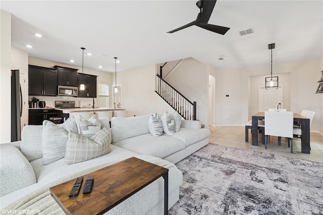 8955 Fluffy Lie Ct, Davenport, FL 33896 - living room with ceiling fan, stairs, light tile patterned floors, recessed lighting, and arched walkways