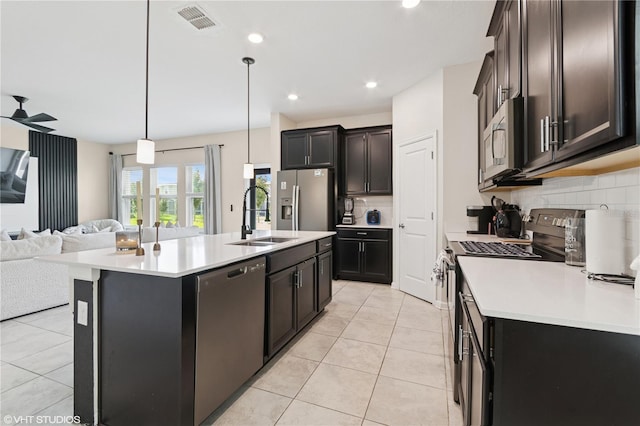 8955 Fluffy Lie Ct, Davenport, FL 33896 - kitchen featuring stainless steel appliances, open floor plan, light countertops, tasteful backsplash, and a kitchen island with sink