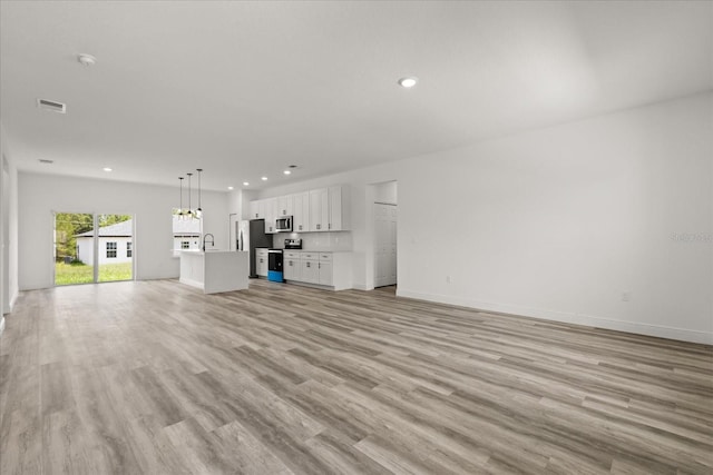 6421 SW 151st Loop, Ocala, FL 34473 - unfurnished living room with recessed lighting, light wood-style floors, and a chandelier