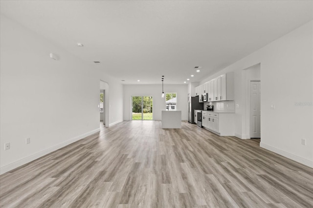 6421 SW 151st Loop, Ocala, FL 34473 - unfurnished living room featuring light wood-style flooring and recessed lighting