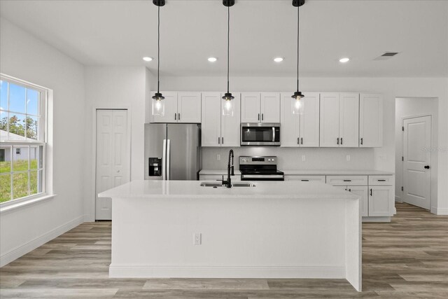 6421 SW 151st Loop, Ocala, FL 34473 - kitchen featuring stainless steel appliances, white cabinets, plenty of natural light, light wood-type flooring, and recessed lighting
