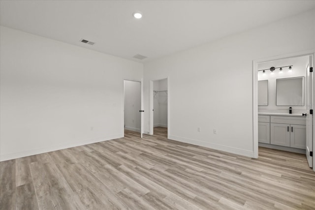 6421 SW 151st Loop, Ocala, FL 34473 - unfurnished bedroom with light wood-style floors, connected bathroom, recessed lighting, a walk in closet, and a closet
