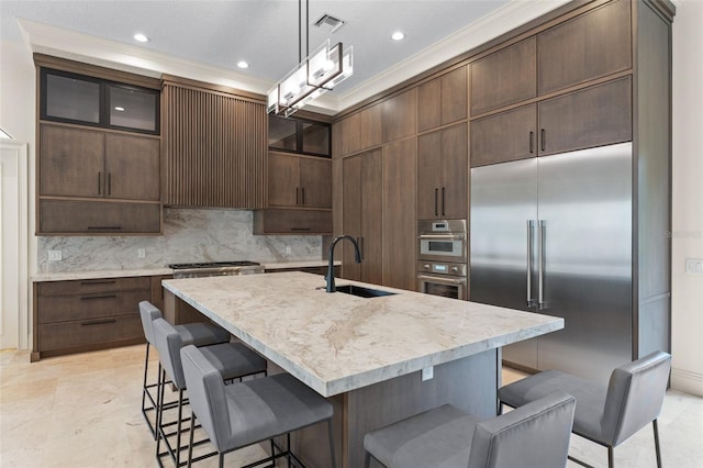 3426 Cocard Ct, Windermere, FL 34786 - kitchen featuring appliances with stainless steel finishes, a breakfast bar, tasteful backsplash, glass insert cabinets, and crown molding