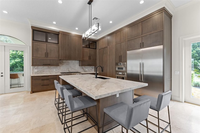 3426 Cocard Ct, Windermere, FL 34786 - kitchen featuring appliances with stainless steel finishes, tasteful backsplash, a kitchen bar, recessed lighting, and plenty of natural light