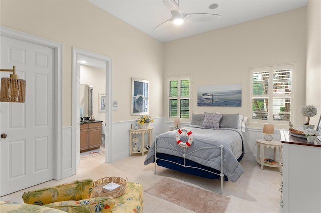 3426 Cocard Ct, Windermere, FL 34786 - bedroom featuring ensuite bath, wainscoting, a ceiling fan, and light colored carpet