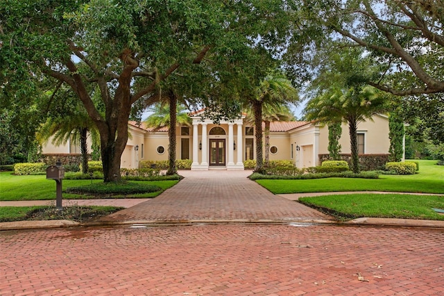3426 Cocard Ct, Windermere, FL 34786 - mediterranean / spanish house featuring french doors, stucco siding, a front lawn, decorative driveway, and a tile roof