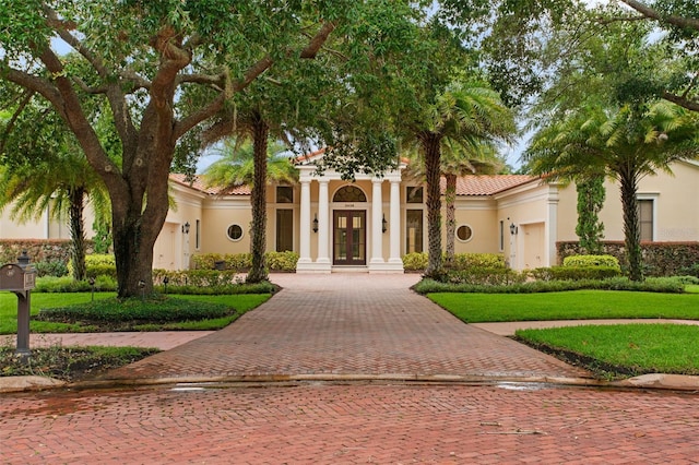 3426 Cocard Ct, Windermere, FL 34786 - mediterranean / spanish-style home featuring french doors, stucco siding, a tile roof, a front lawn, and decorative driveway