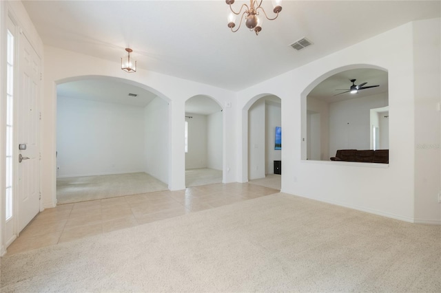 2782 Cedar Knoll Dr, Apopka, FL 32712 - carpeted empty room featuring ceiling fan, tile patterned flooring, arched walkways, and a chandelier