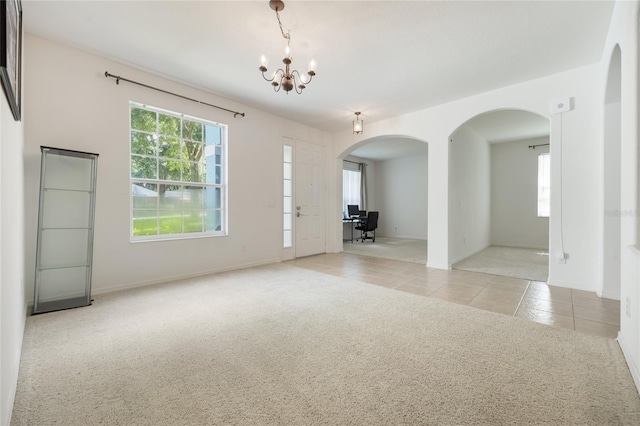 2782 Cedar Knoll Dr, Apopka, FL 32712 - carpeted empty room with arched walkways, a chandelier, and tile patterned flooring