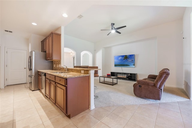 2782 Cedar Knoll Dr, Apopka, FL 32712 - kitchen with light colored carpet, stainless steel appliances, a kitchen bar, open floor plan, and light stone countertops