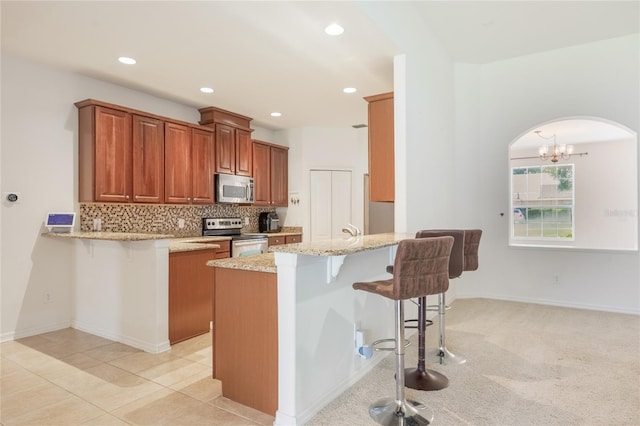 2782 Cedar Knoll Dr, Apopka, FL 32712 - kitchen featuring stainless steel appliances, arched walkways, a peninsula, a kitchen bar, and recessed lighting