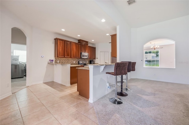 2782 Cedar Knoll Dr, Apopka, FL 32712 - kitchen with stainless steel appliances, arched walkways, a kitchen breakfast bar, a peninsula, and recessed lighting