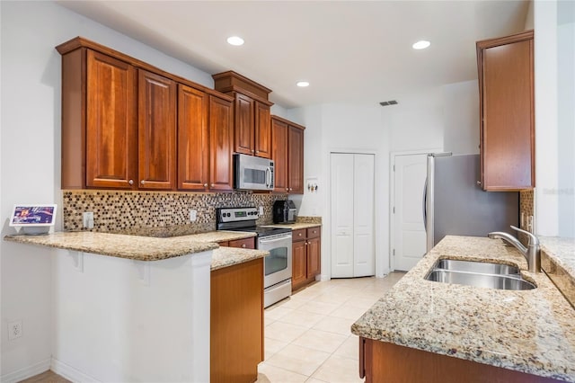 2782 Cedar Knoll Dr, Apopka, FL 32712 - kitchen featuring appliances with stainless steel finishes, a peninsula, light stone counters, backsplash, and light tile patterned flooring