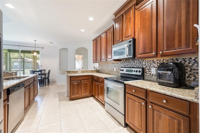 2782 Cedar Knoll Dr, Apopka, FL 32712 - kitchen featuring stainless steel appliances, backsplash, a peninsula, light stone counters, and recessed lighting