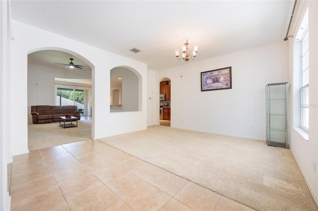 2782 Cedar Knoll Dr, Apopka, FL 32712 - empty room featuring light carpet, arched walkways, ceiling fan, a chandelier, and light tile patterned flooring