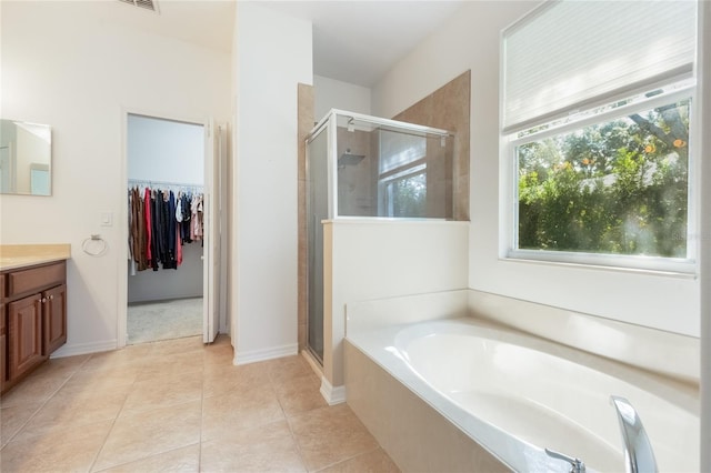 2782 Cedar Knoll Dr, Apopka, FL 32712 - bathroom with vanity, a bath, a shower stall, a walk in closet, and tile patterned floors