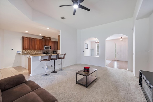 2782 Cedar Knoll Dr, Apopka, FL 32712 - living area with arched walkways, a ceiling fan, light carpet, recessed lighting, and light tile patterned floors