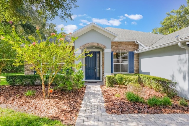 2782 Cedar Knoll Dr, Apopka, FL 32712 - entrance to property with stone siding, stucco siding, and roof with shingles